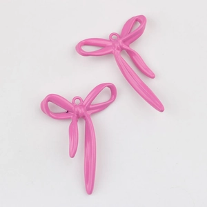 Primer plano de dos colgantes de lazo rosa de aleación para creación de joyas DIY