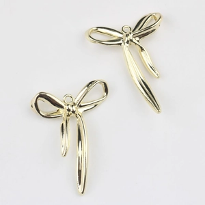 Vista macro de colgantes de aleación dorada con forma de lazo para collares y pendientes DIY