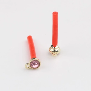 Dettaglio della base dorata con zircone incastonato e perno rosso arancio per creazione gioielli