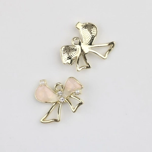 Detailed macro view of pink enamel bow charms with pearls and zircons for DIY jewelry