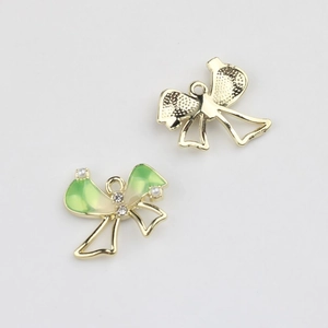 Detail view showing front and back of green enamel bow charm with zircon and pearls