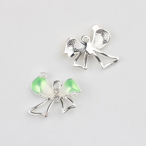 Detail of enamel bow pendant with faux pearls and zircons for DIY jewelry making