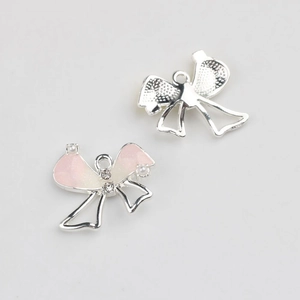 Detail of pink bow pendant charms with glitter and small pearls for DIY jewelry making