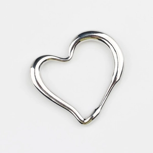 Macro detail of irregular hollow heart pendant with silver polished mirror finish