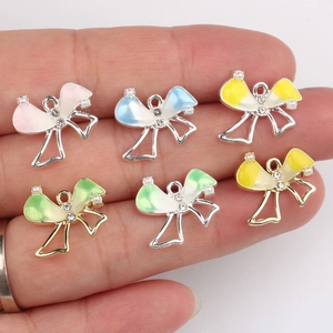 Bow-knot alloy pendant charms with colorful oil drip and crystals held in hand