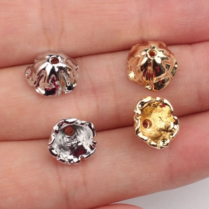 Golden and silver flower bead caps for DIY jewelry making shown on person's hand