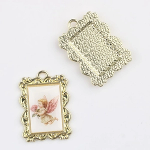 Detail of vintage gold alloy pendants featuring angel painting with baroque wavy edges
