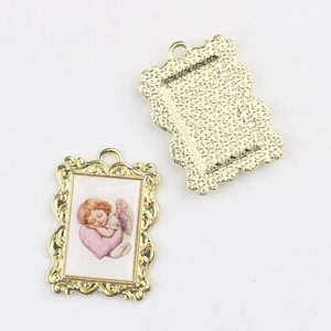 Macro view of vintage alloy angel pendant showing detailed baroque frame and matte back