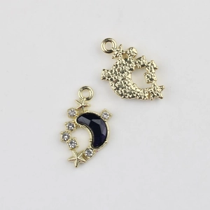 Detail of moon and star gold alloy pendant with purple resin and sparkling rhinestones