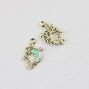 Detail of moon and star pendant with green resin and gold-plated alloy base