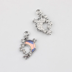 Front and back detail of silver moon and star charms with opal resin and zircon stones