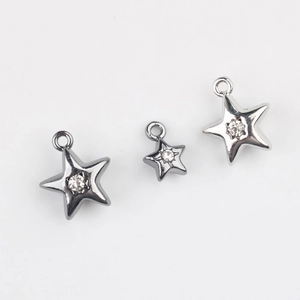 Détail de pendentifs étoile en alliage avec zircons incrustés en argent et noir
