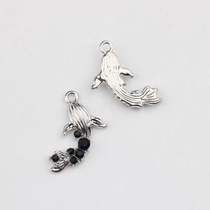 Macro detail of silver fish pendant showing S925 stamp and black zircon inlay