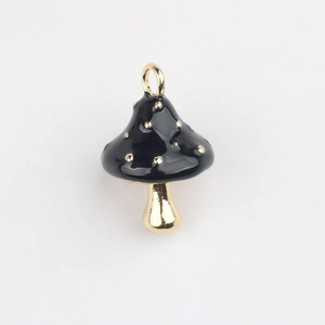 Detailed view of mushroom charm with black enamel and gold polka dots for jewelry