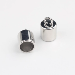 Close-up of shiny silver cylinder end caps with loops for DIY jewelry making