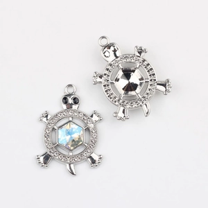 Détail d'un pendentif tortue avec pierres en zircon colorées et dos en métal argenté