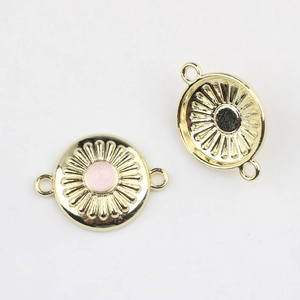 Makroaufnahme goldener Blumenverbinder mit Harz in Pink und Schwarz für DIY-Schmuck