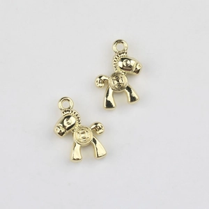 Détail de deux pendentifs cheval dorés avec motifs de pièces pour création de bijoux DIY