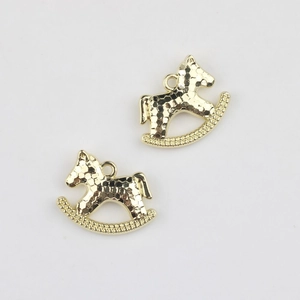 Detailed close-up of golden rocking horse charms with hammered texture for DIY jewelry making