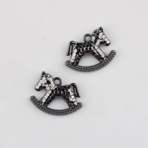 Close-up of gunmetal alloy rocking horse pendants with hammered texture for DIY jewelry making