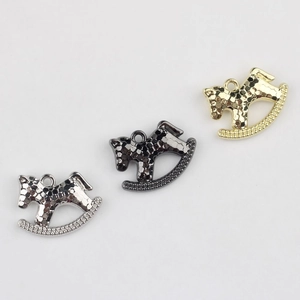 Detailed view of rocking horse pendants in silver, black, and gold with pavé crystals