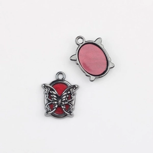 Detailed macro view of butterfly alloy charms with red resin for DIY jewelry making