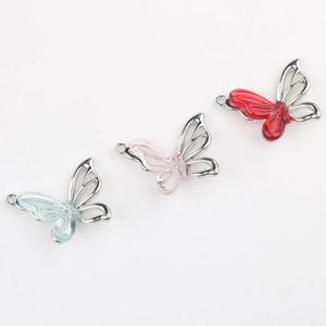 Vue détaillée de pendentifs papillons en résine avec cadres argentés pour bijoux DIY