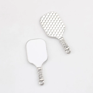 Macro detail of silver alloy pickleball paddle pendants showing honeycomb texture and smooth back