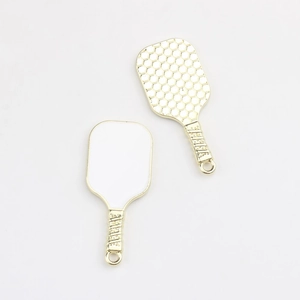 Detailed macro view showing front and honeycomb texture back of gold pickleball paddle charms