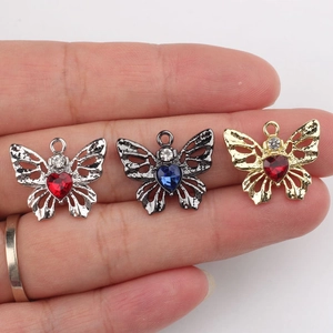 Trois pendentifs papillon en alliage avec pierres de zircon en forme de cœur sur main