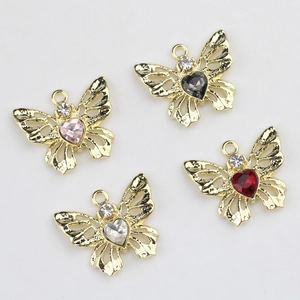 Lot de quatre pendentifs papillons dorés ajourés avec des strass colorés en forme de cœur