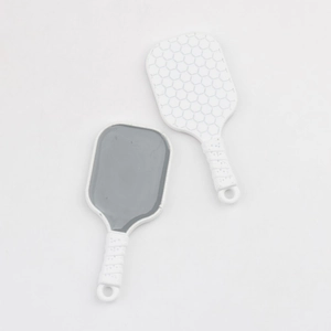Detailed view of two miniature pickleball paddle pendants with honeycomb texture and handles
