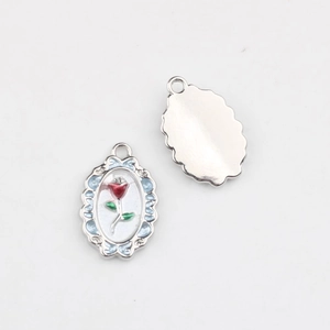 Detail of oval alloy rose pendant with red enamel flower and blue scalloped edge