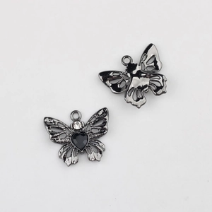 Vue macro du pendentif papillon avec pierre en cœur noire et détails en strass