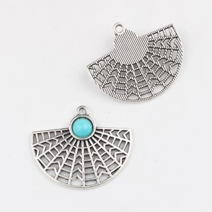 Macro view of vintage silver fan-shaped alloy pendant with turquoise stone inlay