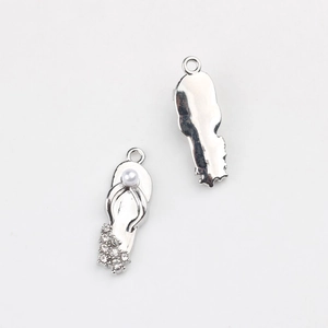 Detail of flip-flop pendants featuring pearls and rhinestones on silver-toned alloy
