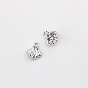 Macro view of two shell charms with silver plating and white pearl inlay for DIY jewelry