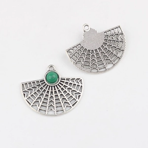 Macro view of hollow fan-shaped charms with green resin stone for DIY jewelry