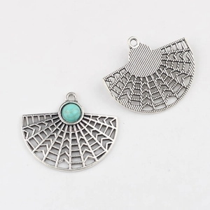 Macro detail of fan-shaped alloy charms with turquoise bead for DIY jewelry making