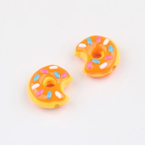 Nahaufnahme von orangefarbenen Acryl-Donut-Perlen mit bunten Streuseln für DIY-Schmuck