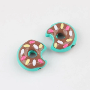 Makro-Detail von Acryl-Donut-Perlen mit Schokoglasur und Streuseln für DIY-Schmuck