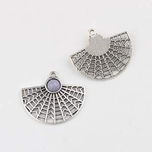 Macro shot of silver alloy fan-shaped pendant with purple stone and hollow radial texture