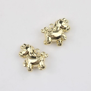 Macro detail of golden alloy horse pendants with floral patterns and integrated loops
