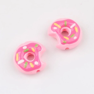 Makroaufnahme von rosa Acryl-Donut-Perlen mit bunten Streuseln für DIY-Schmuckherstellung