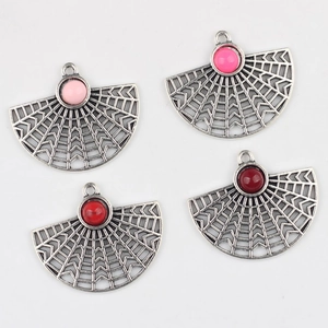 Macro detail of four fan-shaped alloy pendants with resin beads and openwork texture