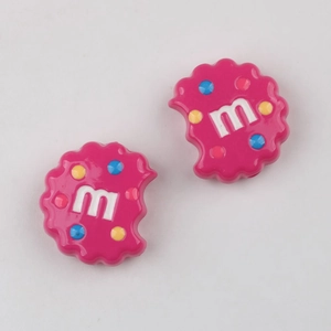 Detail of pink resin cookie charms with colorful mini beans and m letter for DIY crafts