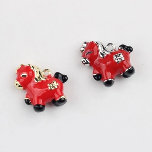 Macro shot of gold and silver plated red enamel pony charms for DIY jewelry making