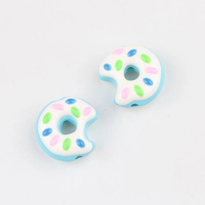 Makroaufnahme von blauen Acryl-Donut-Perlen mit bunten Streuseln für DIY-Schmuckherstellung