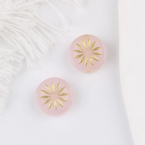 Makroansicht runder rosa Glasperlen mit goldenem Sonnenblumenmuster für DIY-Schmuck