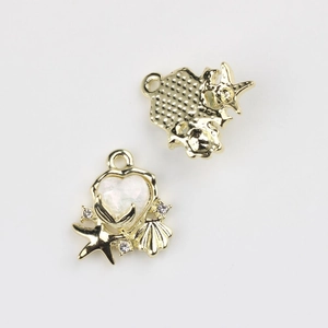 Macro detail of heart-shaped ocean pendants with starfish, shells and gold plating